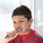 young boy brushing his teeth