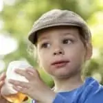 toddler with hat drinking juice