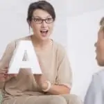 woman holding up letter lauguage tutor